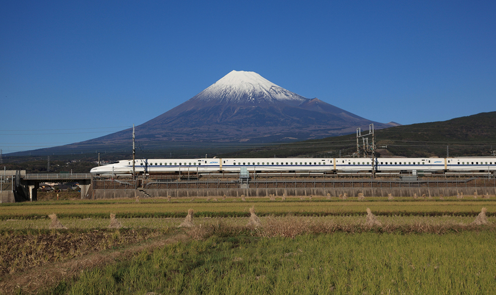 雄大な富士山の前を横切る新幹線